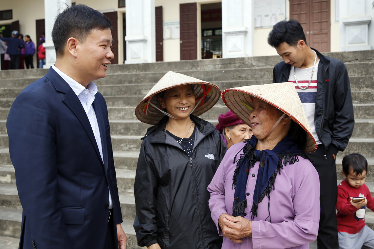 Nhà báo Nguyễn Tiến Bình - Tổng biên tập Báo điện tử Giáo dục Việt Nam, đang hỏi thăm đời sống của bà Lê Thị Gái 83 tuổi. Ảnh: Tùng Dương.