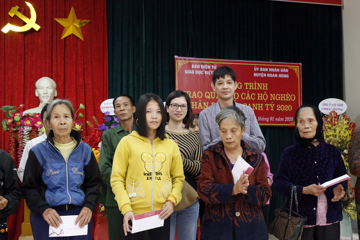 Bà Nguyễn Ngọc vân - cán bộ của Báo điện tử Giáo dục Việt Nam và ông Nguyễn Khắc Chiến - Phó trưởng phòng Lao động - Thương binh và Xã hội huyện Đoan Hùng đang trao quà Tết cho các hộ dân của xã Phú Lâm. Ảnh: Tùng Dương.
