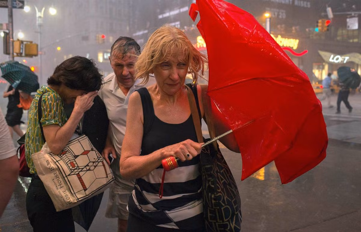 Người dân đi bộ trong mưa to gió lớn tại trung tâm Manhattan, Mỹ ngày 18/7.