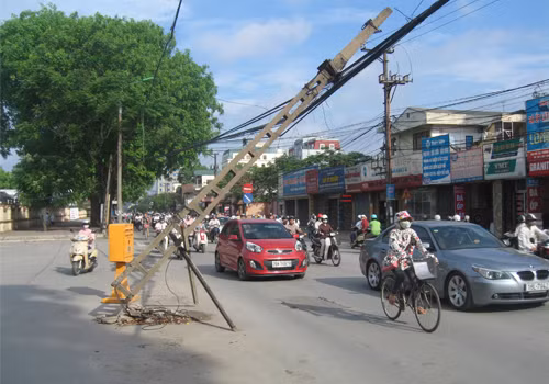 Cột điện đổ gây nguy hiểm cho người đi đường, chụp sáng 9/5/2012 trên đường Trường Chinh (Hà Nội). Ảnh: Lê Hội. Cột điện đổ gây nguy hiểm cho người đi đường, chụp sáng 9/5/2012 trên đường Trường Chinh (Hà Nội). Ảnh: Lê Hội.