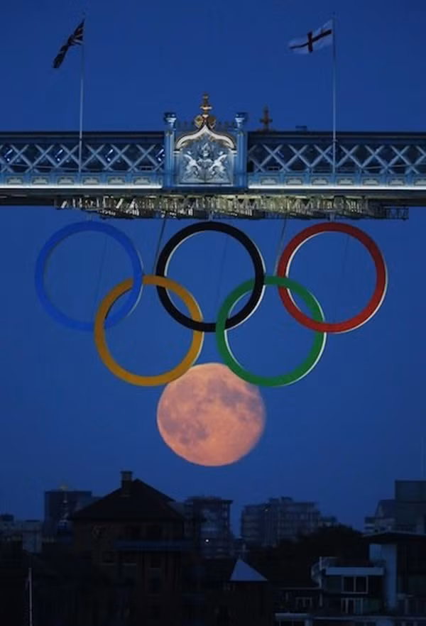 Đó là hình ảnh mặt trăng tròn vành vạnh nằm ngay chính giữa 5 vòng tròn trên logo của Olympic, tạo thành một vòng tròn hoàn hảo. Trăng tròn nhuốm màu sẫm vàng giống như một chiếc nhẫn độc đáo thứ 6 trên đường chân trời London. Đó là hình ảnh mặt trăng tròn vành vạnh nằm ngay chính giữa 5 vòng tròn trên logo của Olympic, tạo thành một vòng tròn hoàn hảo. Trăng tròn nhuốm màu sẫm vàng giống như một chiếc nhẫn độc đáo thứ 6 trên đường chân trời London.