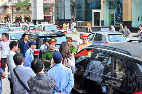 Sau gần một giờ "cố thủ" trong xe, người phụ nữ (mặc váy trắng) mới chịu bước ra. Ảnh: Quốc Anh.