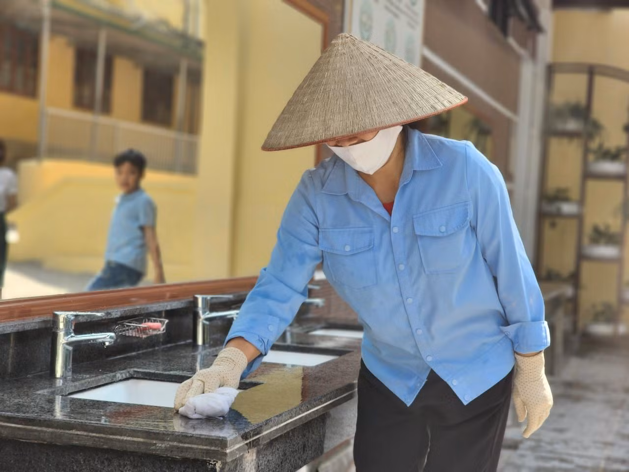 Nhân viên lao công đảm bảo vệ sinh sạch sẽ khu nhà vệ sinh ngay sau mỗi tiết giải lao (Ảnh: Phạm Linh)