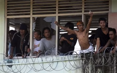 Hình ảnh tù nhân Kerobokan tại nhà tù Denpasar, Indonesia đứng từ trong tường rào thép gai nhìn ra.