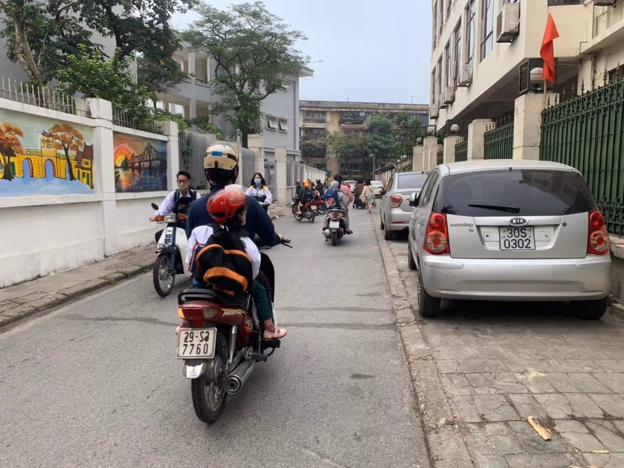 Theo ghi nhận của phóng viên Tạp chí Điện tử Giáo dục Việt Nam, 6h30 sáng, đoạn đường vào Trường Phổ thông Trung học Kim Liên (Đống Đa, Hà Nội) có rất nhiều học sinh đi xe gắn, xe máy điện, xe đạp điện nhưng không đội mũ bảo hiểm. Ảnh: Kim Anh.