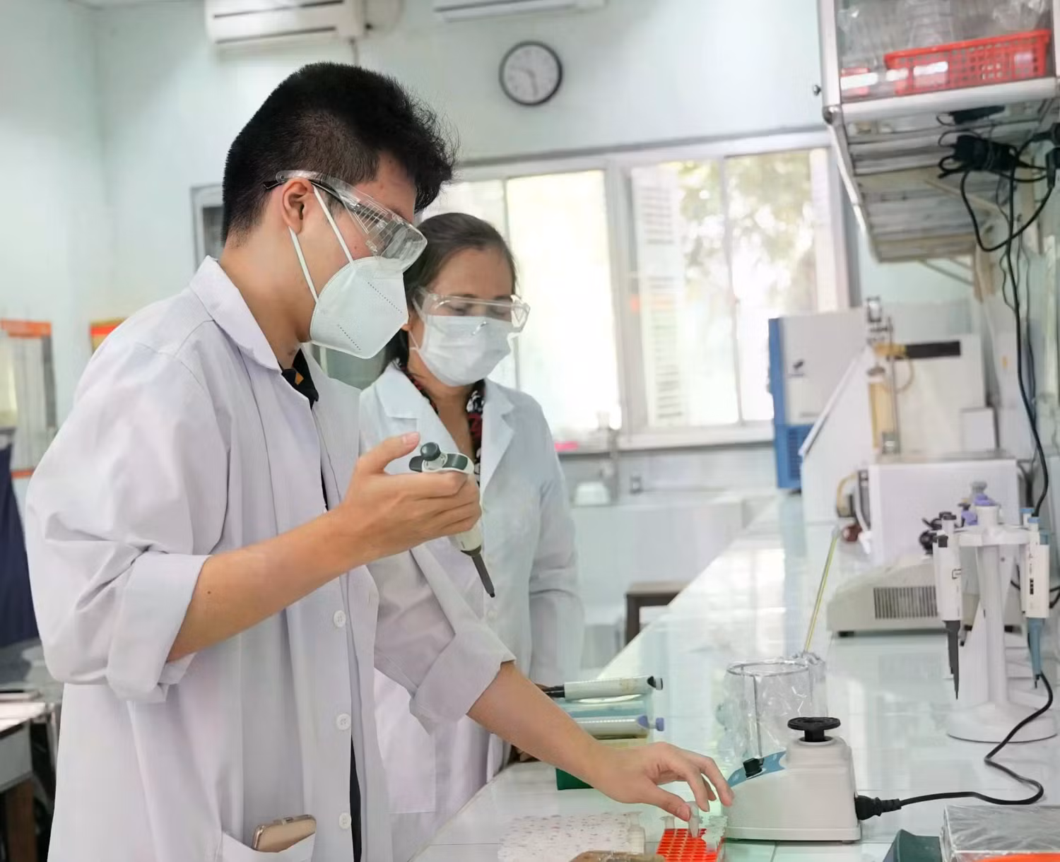 Sinh viên (trái) Trường Đại học Bách Khoa, Đại học Quốc gia thành phố Hồ Chí Minh đang thực hành tại Phòng Thí nghiệm Công nghệ Vi sinh dưới sự hướng dẫn của giảng viên. Ảnh Website trường