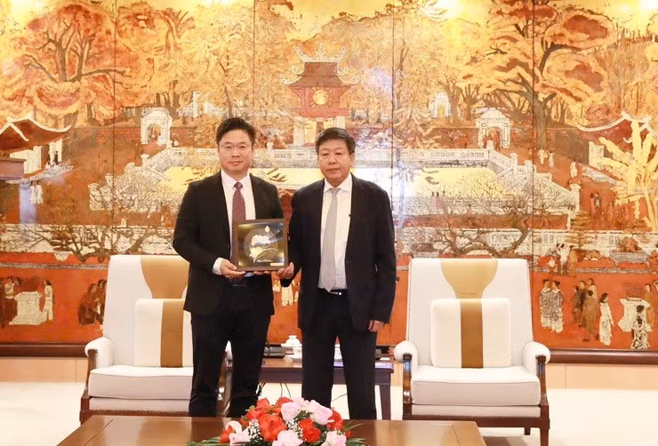 Phó Chủ tịch Thường trực Ủy ban nhân dân thành phố Hà Nội Dương Đức Tuấn trao quà lưu niệm tặng Phó Chủ tịch Hội đồng quản trị Tống Hiệp Bằng. Ảnh: hanoi.gov.vn.