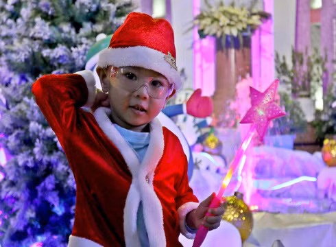 Em bé thích thú khi được mặc đồ ông già Noel trong dịp Giáng sinh về (ảnh: T.P)