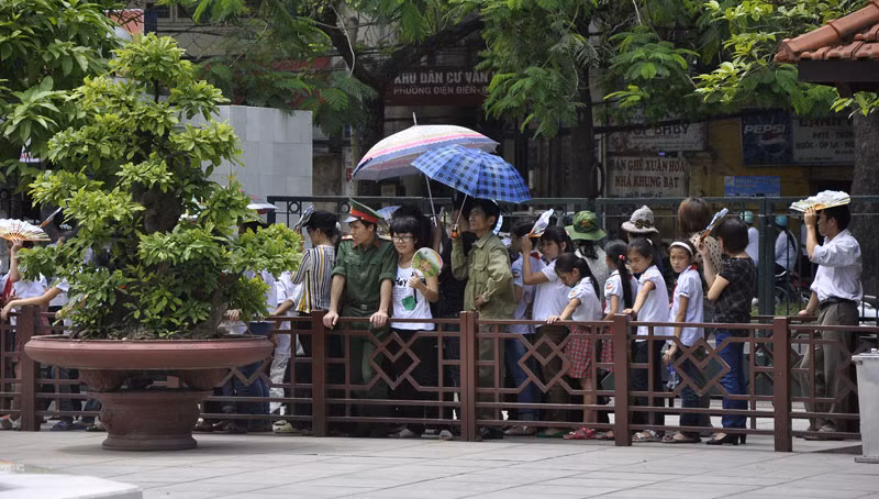 Nhiều người đã dùng ô để làm giảm đi cái nắng trên con đường vào lăng.
