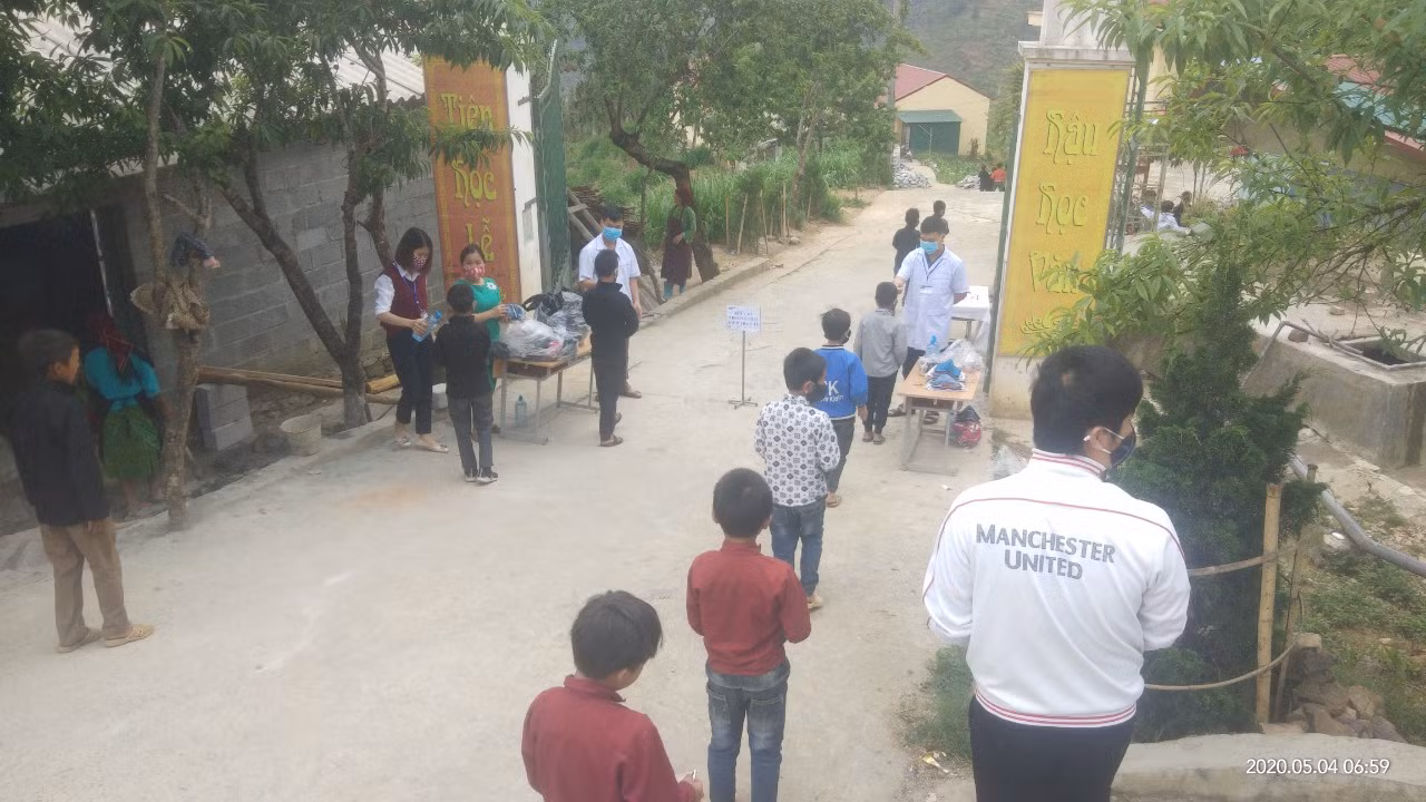 Học sinh trường Sảng Tủng đứng giãn cách để kiểm tra y tê.