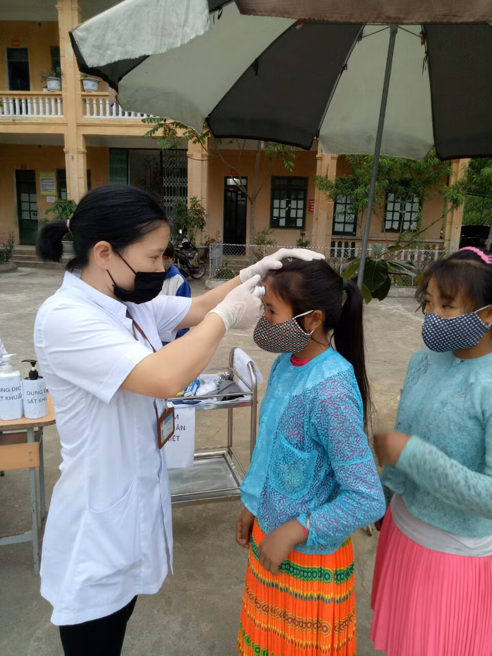 Các em nữ sinh trường Trung học cơ sở Lũng Phìn đo nhiệt độ trước khi vào học.