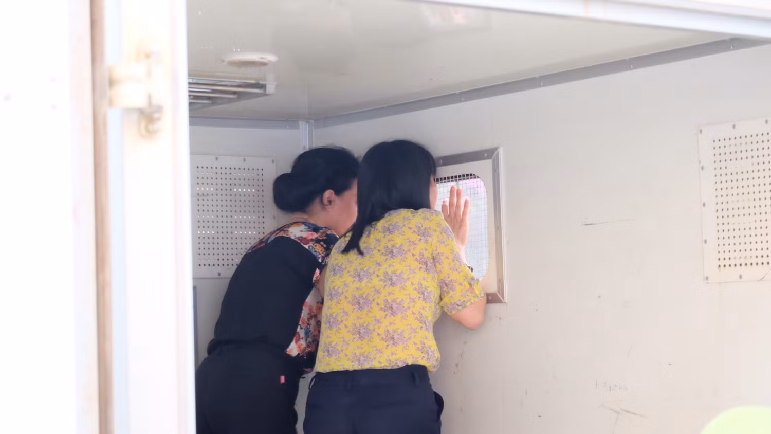 Hai bị cáo Liên và Loan gọi người thân sau cánh xe tù. Hai bị cáo Liên và Loan gọi người thân sau cánh xe tù.