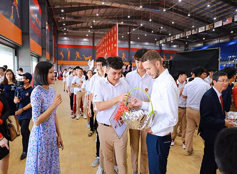 Tặng quà cho học sinh đến dự lễ khai giảng ở IEC Quảng Ngãi (ảnh: NHG)