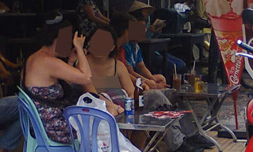 Các chân dài ngồi trên phố chờ khách. Ảnh: ANTG.