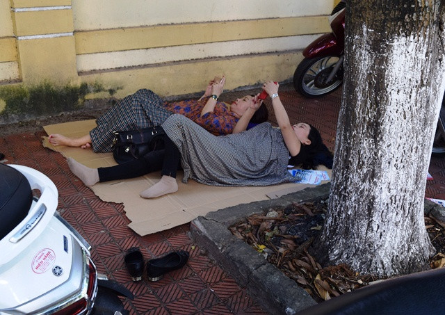 Phụ huynh trong lúc đợi con làm bài thi tại điểm thi trường trung học phổ thông Đào Duy Từ (Quảng Bình). (Ảnh: Thủy Phan)