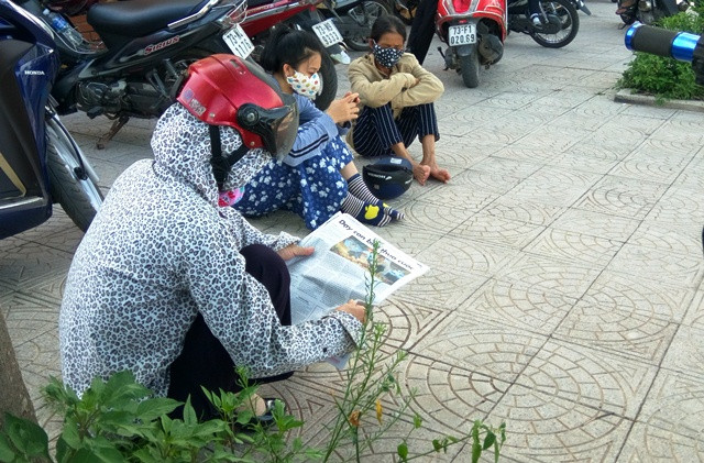 Nhiều phụ huynh ngồi bệt ngoài hè đường chờ con thi. (Ảnh: Thủy Phan)