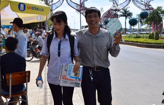 Hai bố con vui vẻ rời khu vực thi sau khi con gái hoàn thành bài thi môn Ngữ Văn. (Ảnh: Thủy Phan)