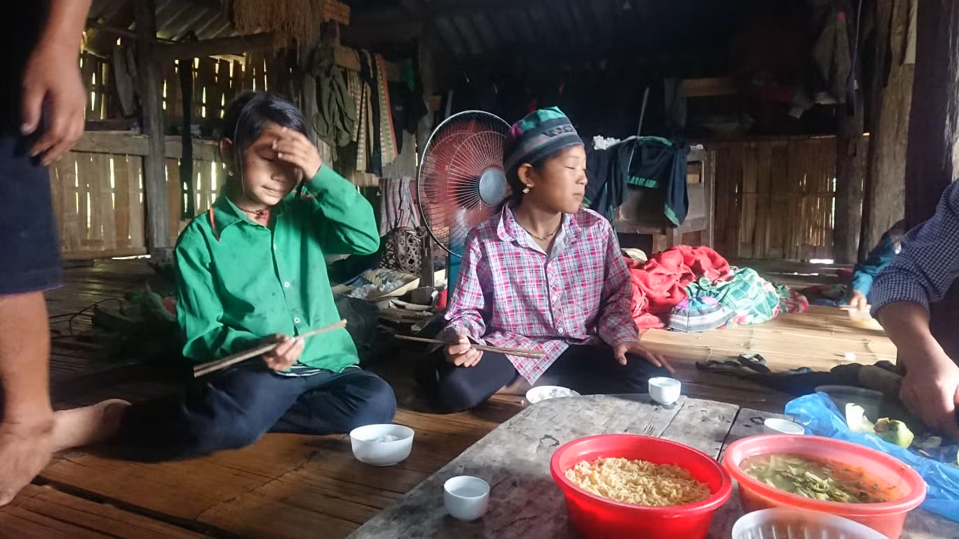 Ly Thị Óng (áo xanh) và bữa cơm với mỳ tôm của những đứa trẻ người La Chí. (Ảnh Nguyễn Toan) Ly Thị Óng (áo xanh) và bữa cơm với mỳ tôm của những đứa trẻ người La Chí. (Ảnh Nguyễn Toan)