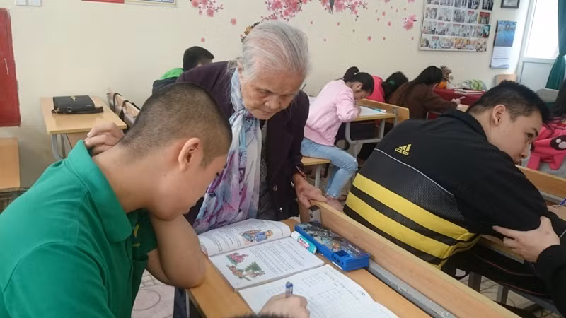 Cụ Hồ Hương Nam đang hướng dẫn cho các em học sinh học tập. Ảnh: Mai Ly.