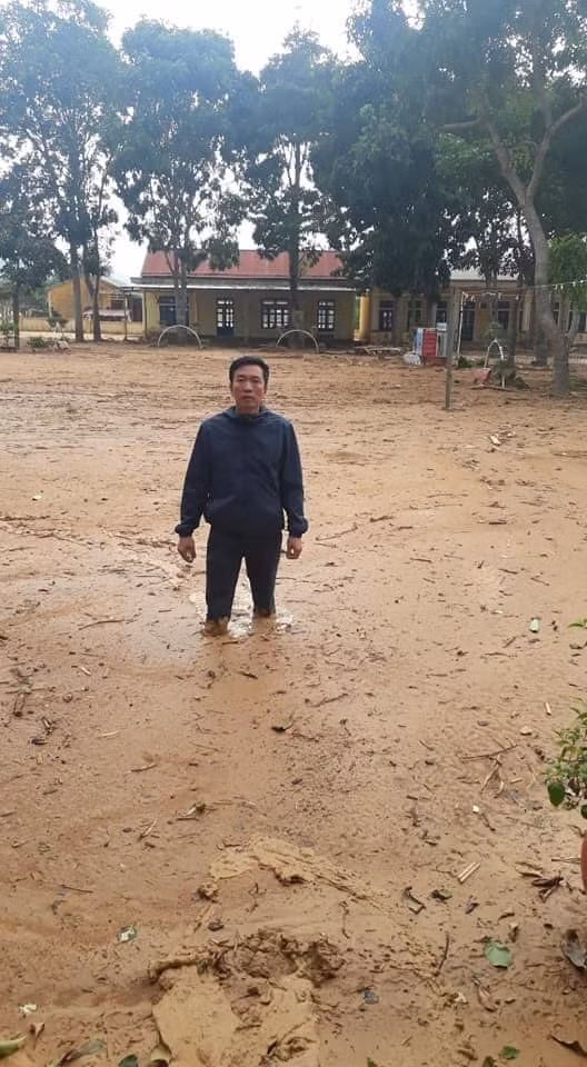 Thầy Nguyễn Văn Tý, hiệu trưởng trường Tiểu học và Trung học cơ sở Hướng Việt đứng gữa sân trường đầy sình, đất gần nửa mét đang vô cùng lo lắng
