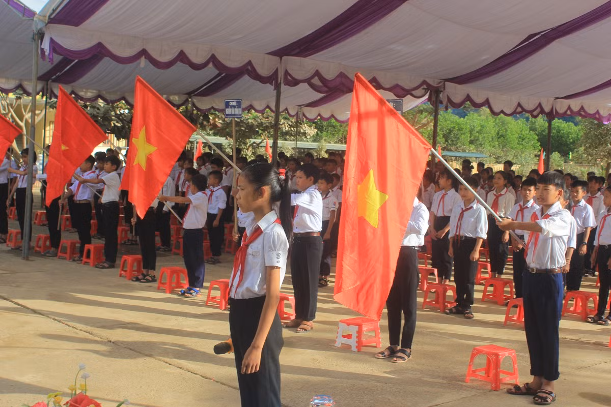 Học sinh ở Tân Hóa dự lễ khai giảng chậm hơn so với các trường khác do mưa lũ.