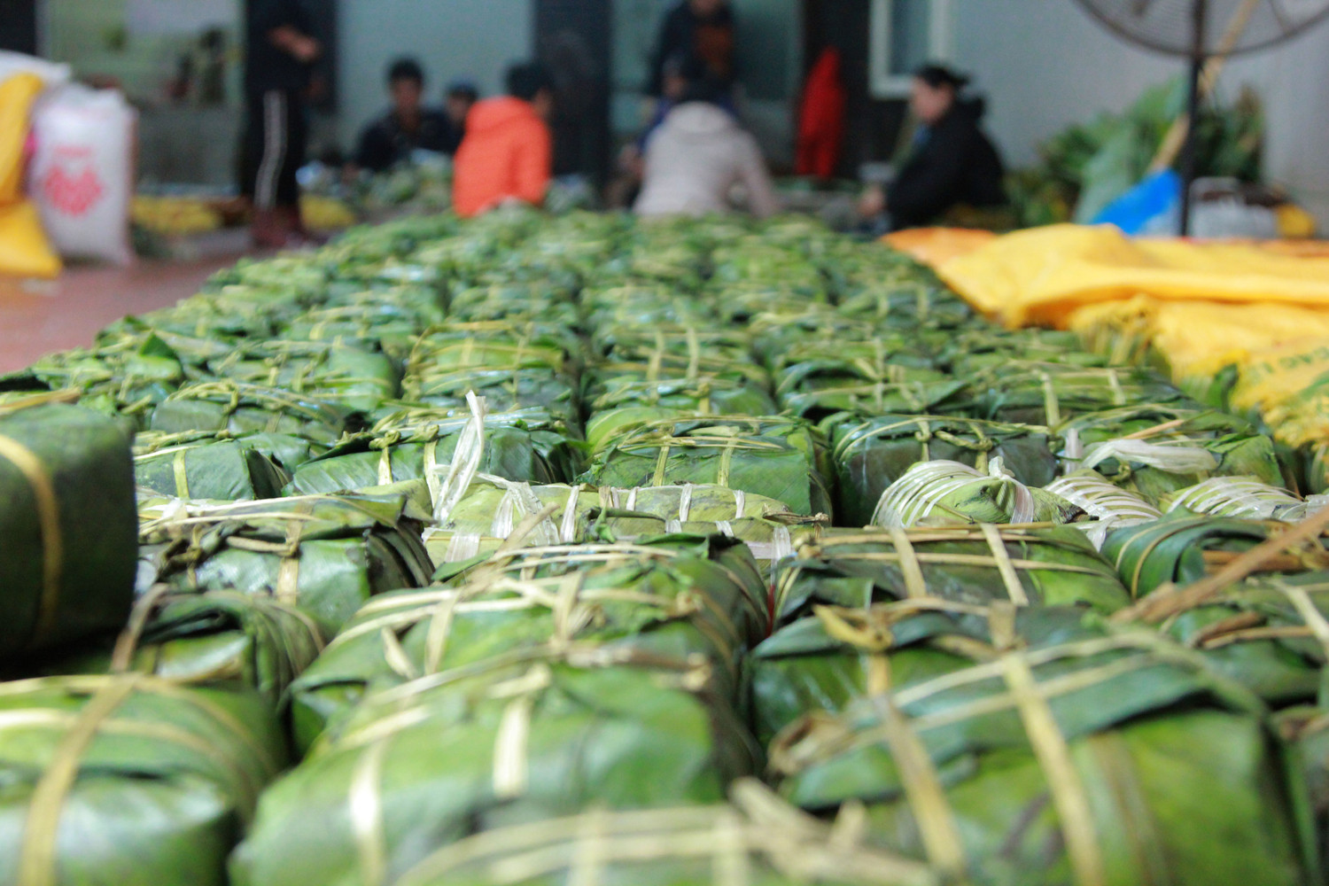 Ngay từ đầu cổng, hàng trăm chiếc bánh chưng đã được luộc chín xếp ngăn nắp trên giá gỗ. (Ảnh: Mạnh Đoàn)