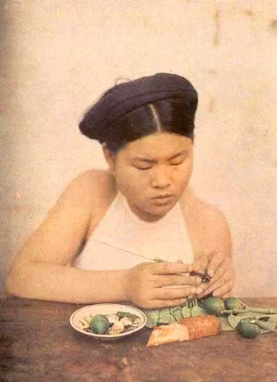 ... Nhưng cách ăn của phụ nữ Hà Nội dễ nhận ra ngay: ý tứ, ngồi một góc, khép chân, không gác chân co lên ghế, không gục mặt xuống mà ăn, vẫn thẳng thắn, đàng hoàng, không liếc ngang liếc dọc. Không nhồm nhoàm, không xì xụp, không tóp tép, không ừng ực, không nói cười hô hố trong khi ăn. Ăn xong kín đáo rút khăn tay lau miệng chứ không dùng đũa dựng đứng mà quệt như phù thuỷ niệm thần chú, bắt quyết. Trong ảnh: Cô gái Hà Nội ngồi têm trầu - 1916. ... Nhưng cách ăn của phụ nữ Hà Nội dễ nhận ra ngay: ý tứ, ngồi một góc, khép chân, không gác chân co lên ghế, không gục mặt xuống mà ăn, vẫn thẳng thắn, đàng hoàng, không liếc ngang liếc dọc. Không nhồm nhoàm, không xì xụp, không tóp tép, không ừng ực, không nói cười hô hố trong khi ăn. Ăn xong kín đáo rút khăn tay lau miệng chứ không dùng đũa dựng đứng mà quệt như phù thuỷ niệm thần chú, bắt quyết. Trong ảnh: Cô gái Hà Nội ngồi têm trầu - 1916.
