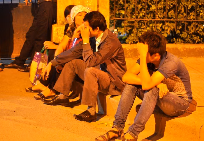 Nhiều người ngồi ngay trước cổng tranh thủ chợp mắt.
