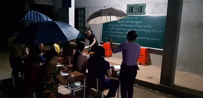 Những ngày mưa, bà con vừa che ô, vừa học (Ảnh:H.H)
