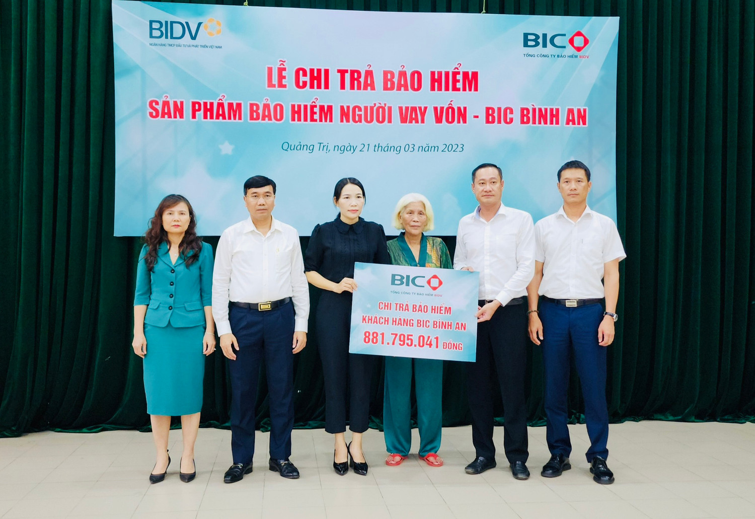 Đại diện lãnh đạo BIC và BIDV Quảng Trị trao tiền bảo hiểm cho khách hàng.