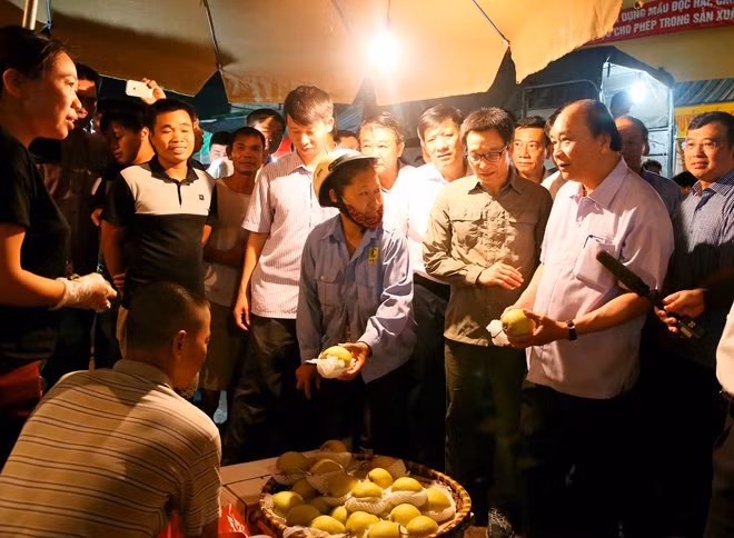 Thủ tướng Nguyễn Xuân Phúc và Phó Thủ tướng Vũ Đức Đam trong lần thị sát tại chợ đầu mối Long Biên. ảnh: TTXVN.