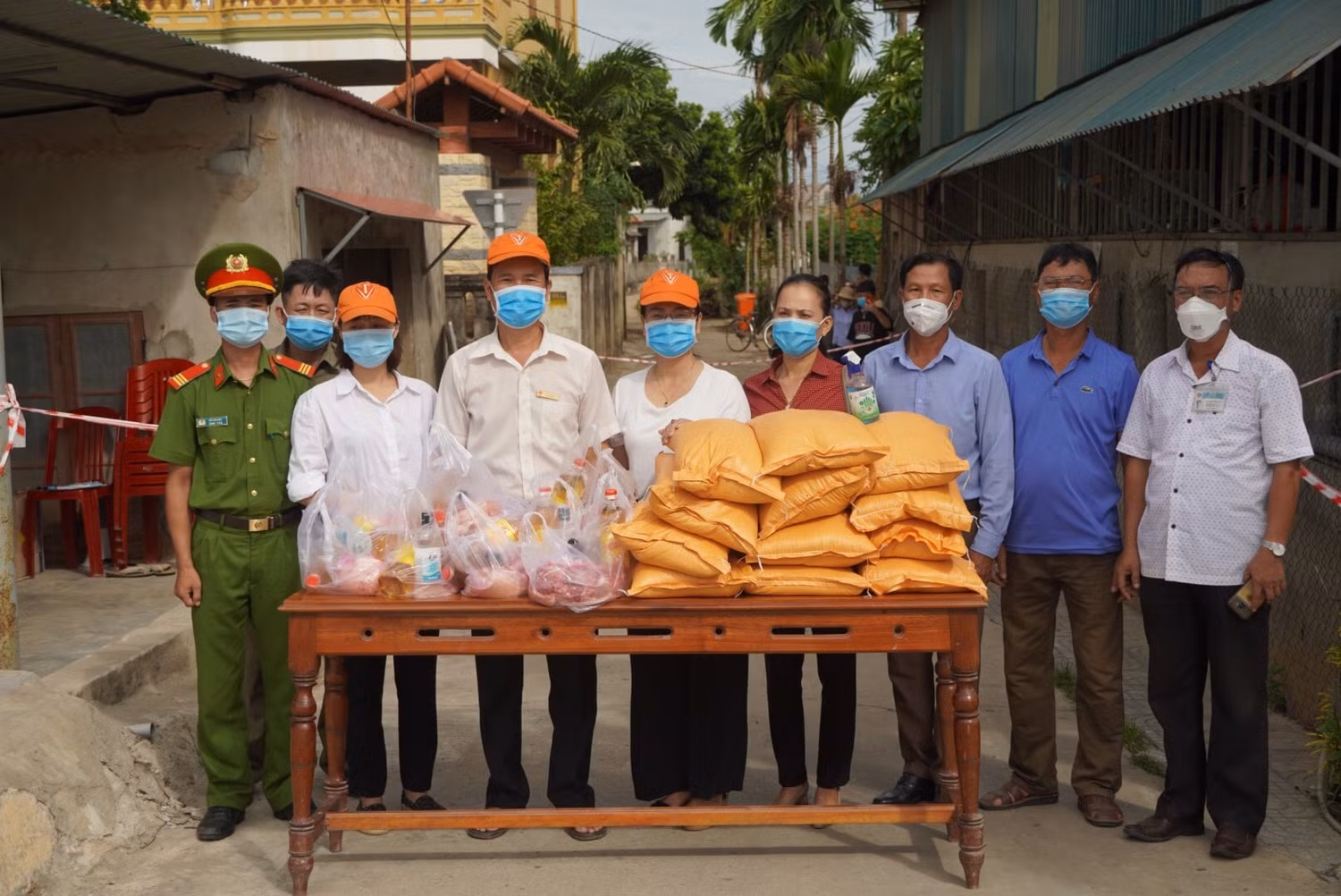 Gạo, dầu ăn, thịt heo...được trao cho những người dân vùng bị phong tỏa tạm thời (Ảnh nhà trường)