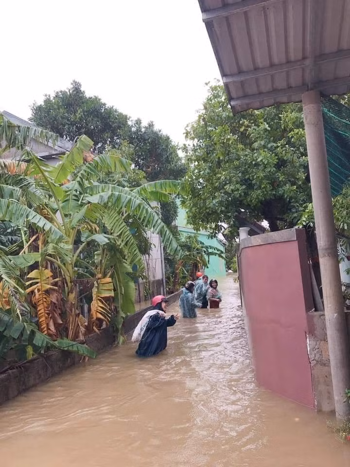 Nước ngập ngang người nhưng cô giáo vẫn đi vào từng nhà phát quà