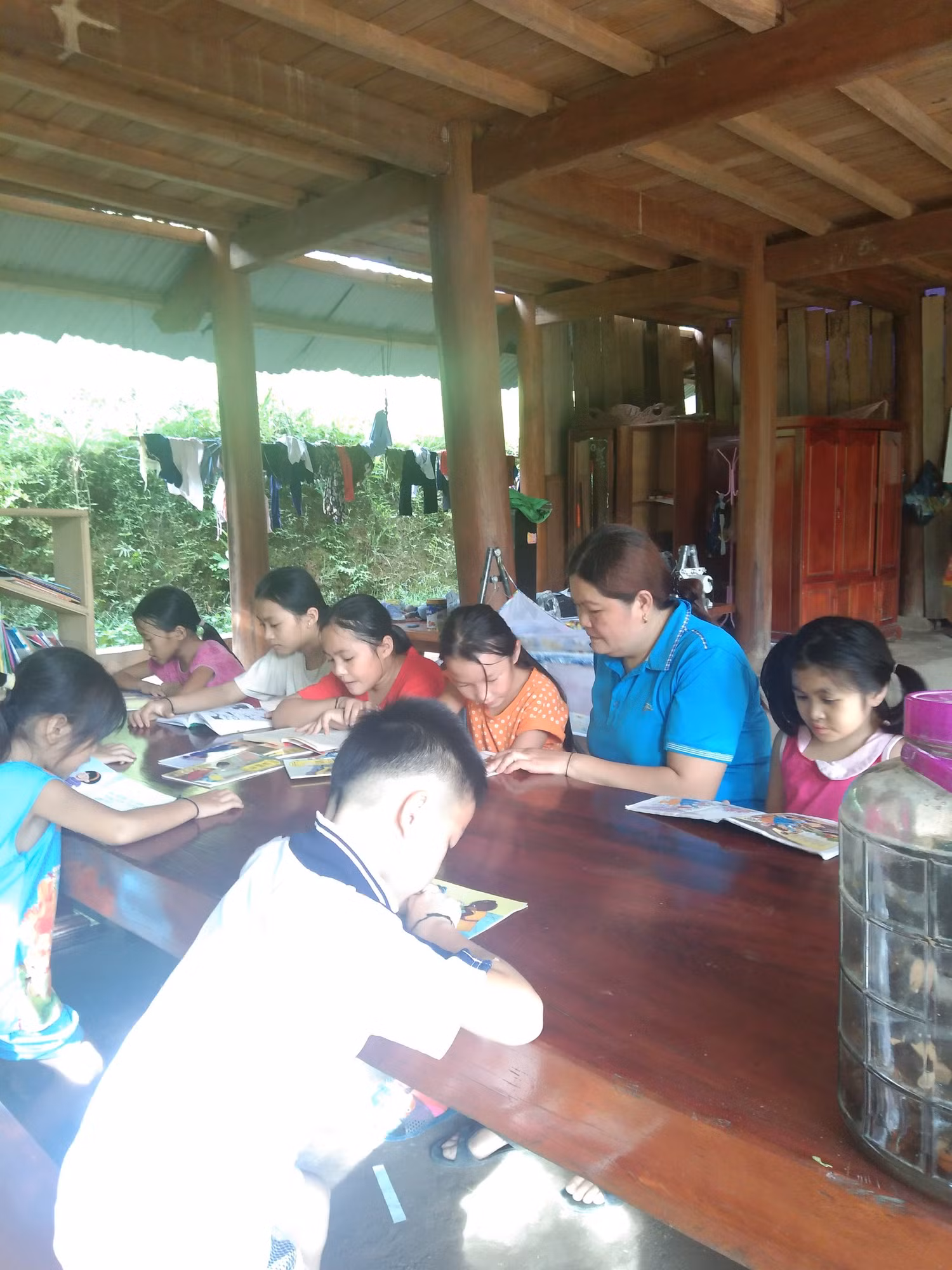 Kèm học sinh yếu đọc (Ảnh nhà trường cung cấp)
