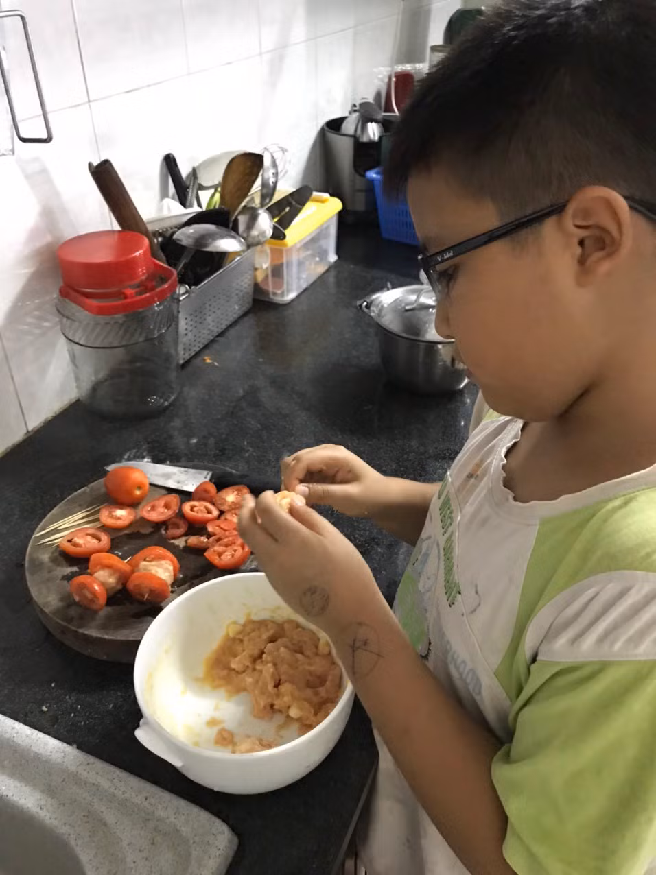 Em Nguyễn Đăng Sỹ Hoàng đang giúp mẹ nấu cơm trưa (Ảnh: Sơn Quang Huyến)