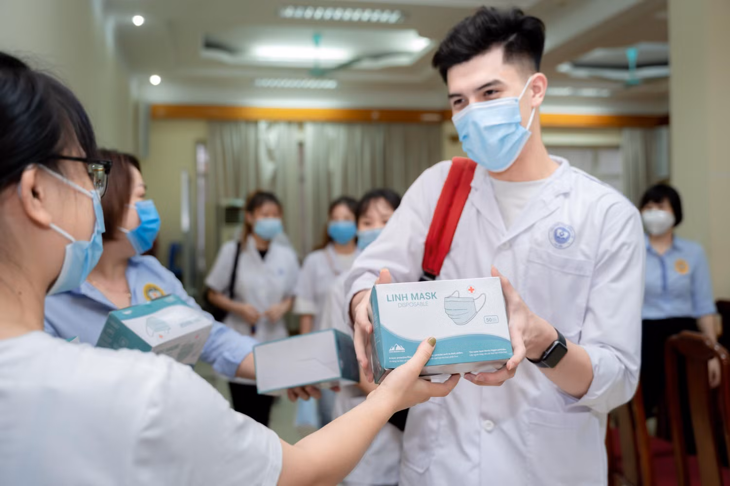 Tình nguyện viên nhận khẩu trang y tế chuẩn bị làm nhiệm vụ tại CDC Hà Nội. (Ảnh: Nhà trường cung cấp)