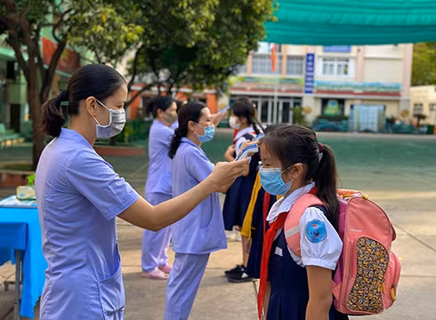 Học sinh trường tiểu học Lạc Long Quân, quận 11 được đo thân nhiệt trước khi vào lớp (ảnh: P.L) Học sinh trường tiểu học Lạc Long Quân, quận 11 được đo thân nhiệt trước khi vào lớp (ảnh: P.L)