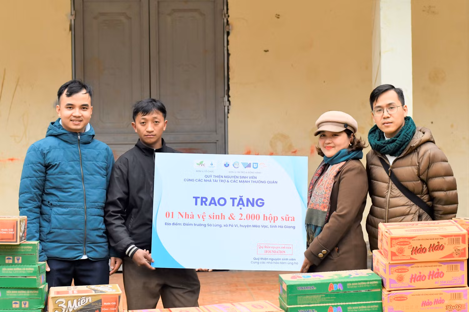 Anh Nguyễn Ngọc Huân (ngoài cùng, bên trái) tặng nhà vệ sinh và 2.000 hộp sữa cho điểm Trường Mầm non Sà Lủng, xã Pả Vi, huyện Mèo Vạc, tỉnh Hà Giang. Tiếp nhận quà tặng là ông Thò Mí Pó (thứ hai, bên trái sang) - Trưởng thôn Sà Lủng và cô Nguyễn Thị Hạnh - Hiệu trưởng Trường Mầm non Pả Vi. Ảnh: Ngọc Mai.