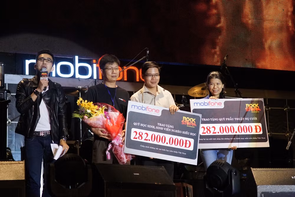 Đại diện MobiFone trao tặng số tiền từ thiện cho Quỹ Phẫu thuật nụ cười (ngoài cùng bên phải) và Quỹ Học sinh – sinh viên nghèo hiếu học của Trung ương Đoàn trên sân khấu RockStorm TP.Hồ Chí Minh Đại diện MobiFone trao tặng số tiền từ thiện cho Quỹ Phẫu thuật nụ cười (ngoài cùng bên phải) và Quỹ Học sinh – sinh viên nghèo hiếu học của Trung ương Đoàn trên sân khấu RockStorm TP.Hồ Chí Minh