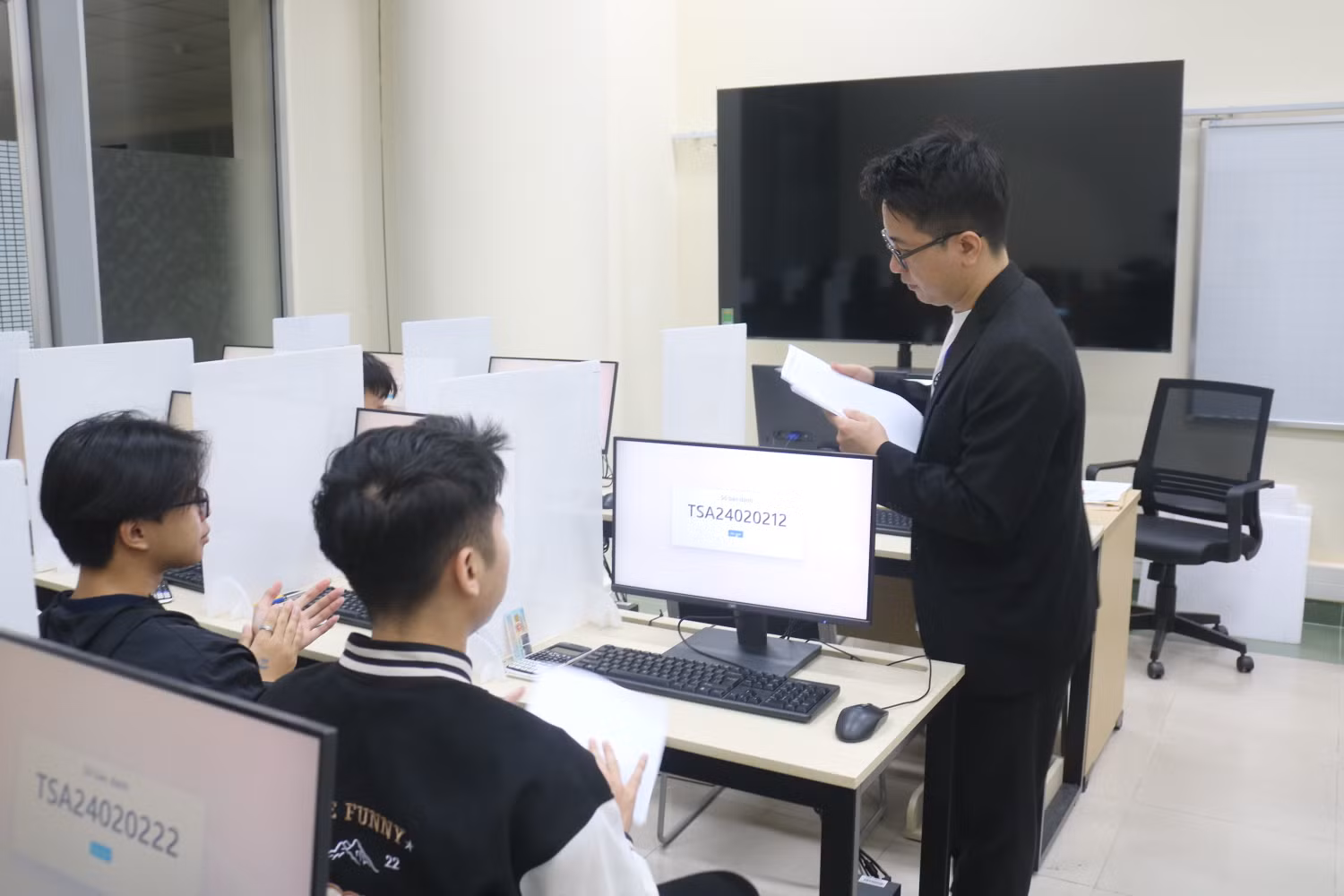 Giám thị phát giấy nháp cho thí sinh. Ảnh: Doãn Nhàn