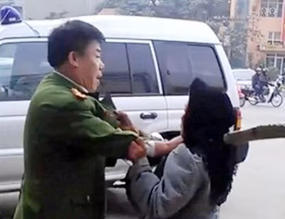 Một cán bộ ngành công an xô ngã một cụ già (ảnh cắt từ clip) Một cán bộ ngành công an xô ngã một cụ già (ảnh cắt từ clip)
