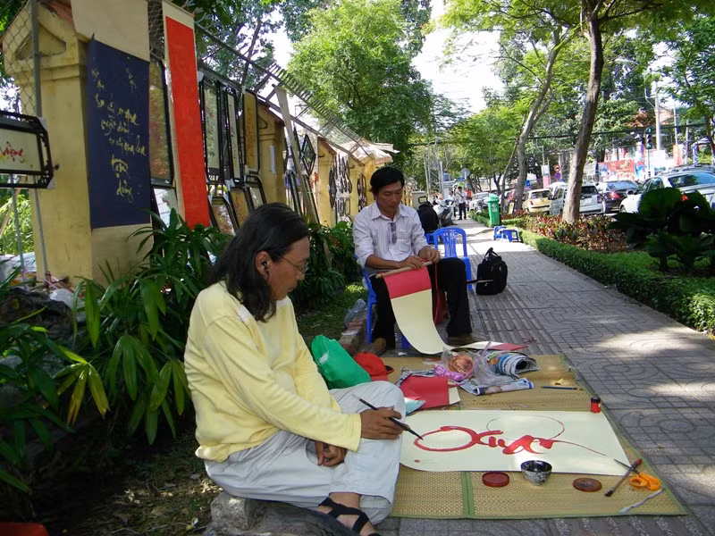 Vẻ mặt đăm chiêu của “ông đồ” Bùi Hiến trước khung cảnh hịu quạnh khách. Anh là anh, em chú bác ruột với thi sĩ trứ danh Bùi Giáng (bố của anh là anh ruột của bố thi sĩ). Anh chính là người “sáng lập” ra góc phố ông đồ trên đường Trương Định. 11 lần tết đến, anh đều đã ngồi ngay góc phố này Vẻ mặt đăm chiêu của “ông đồ” Bùi Hiến trước khung cảnh hịu quạnh khách. Anh là anh, em chú bác ruột với thi sĩ trứ danh Bùi Giáng (bố của anh là anh ruột của bố thi sĩ). Anh chính là người “sáng lập” ra góc phố ông đồ trên đường Trương Định. 11 lần tết đến, anh đều đã ngồi ngay góc phố này