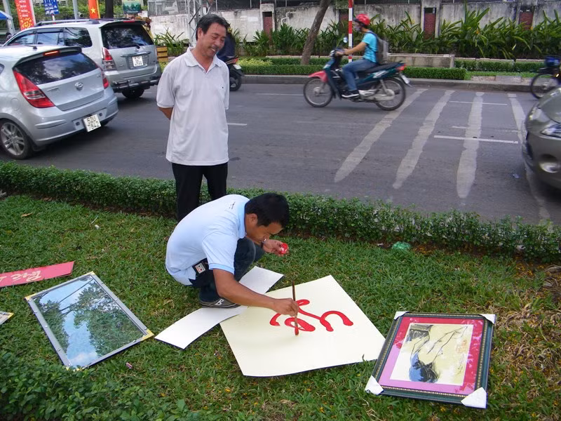 Khách hàng Hoàng Ngọc Thạch đang “xin chữ” (hay mua chữ?) của “ông đồ” Trần Phong. Anh Thạch đang chờ Phong viết xong chữ “lộc”, với giá 150 ngàn. Anh Thạch cho biết: “Vợ tôi tên Lộc nên tôi muốn dành món quà bất ngờ tặng cho bà ấy trong dịp tết”. Khách hàng Hoàng Ngọc Thạch đang “xin chữ” (hay mua chữ?) của “ông đồ” Trần Phong. Anh Thạch đang chờ Phong viết xong chữ “lộc”, với giá 150 ngàn. Anh Thạch cho biết: “Vợ tôi tên Lộc nên tôi muốn dành món quà bất ngờ tặng cho bà ấy trong dịp tết”.