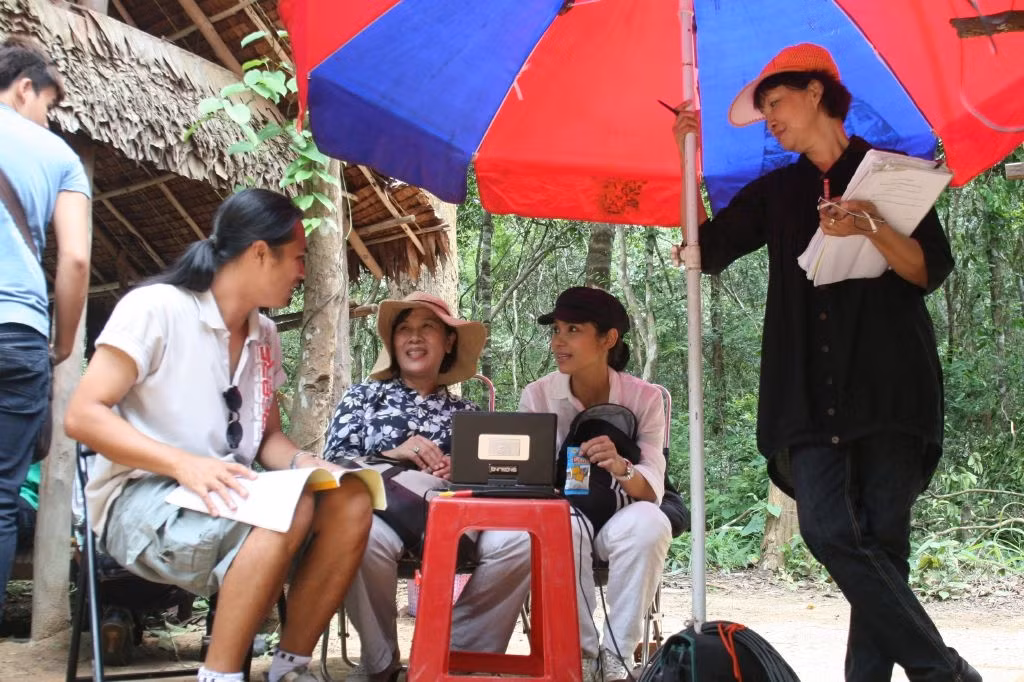 Việt Trinh (áo hồng, ngồi) trong vai trò đạo diễn, đang chỉ đạo diễn xuất phim Trở về. Việt Trinh (áo hồng, ngồi) trong vai trò đạo diễn, đang chỉ đạo diễn xuất phim Trở về.