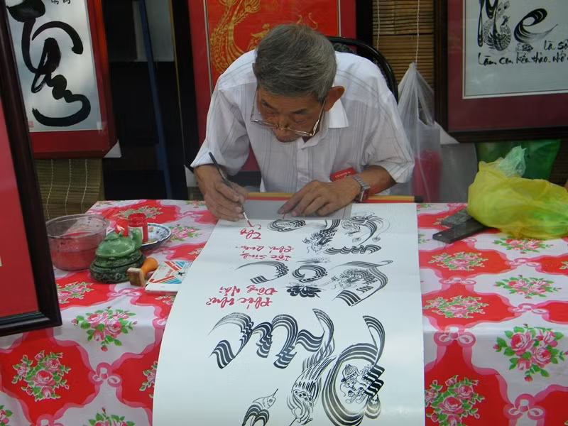 "Ông đồ" già 73 tuổi Thành Trực đang mài nghiên, múa bút 3 chữ "phúc, lộc, thọ". Ông cười buồn cho biết: "Năm nay khách vắng quá chú à. Tôi ngồi đây đã 6 mùa xuân, chưa bao giờ như thế này cả. Tuy buồn nhưng tôi tự an ủi mình là đang mang chút hơi tàn cống hiến mọi người trong ngày xuân". "Ông đồ" già 73 tuổi Thành Trực đang mài nghiên, múa bút 3 chữ "phúc, lộc, thọ". Ông cười buồn cho biết: "Năm nay khách vắng quá chú à. Tôi ngồi đây đã 6 mùa xuân, chưa bao giờ như thế này cả. Tuy buồn nhưng tôi tự an ủi mình là đang mang chút hơi tàn cống hiến mọi người trong ngày xuân".