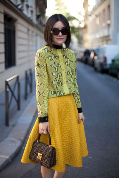 Chiếc áo họa tiết da rắn màu vàng chanh kết hợp với chân váy màu vàng mustard tạo nên một bộ đồ "tone sur tone". Chiếc áo họa tiết da rắn màu vàng chanh kết hợp với chân váy màu vàng mustard tạo nên một bộ đồ "tone sur tone".