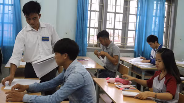 Giám thị coi thi phát giấy cho thí sinh. (Ảnh minh họa: nhandan.com.vn)