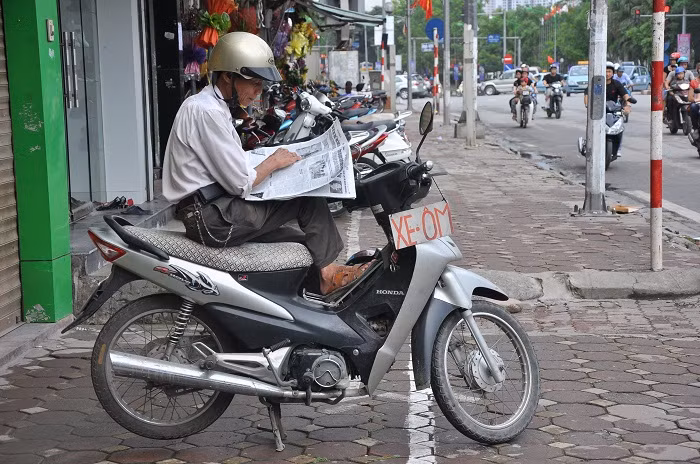 Bác Trung đang tranh thủ đọc báo khi không có khách Bác Trung đang tranh thủ đọc báo khi không có khách