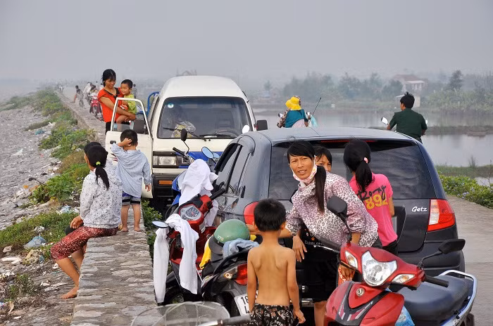Trên đê, xe cộ và người đông đúc.