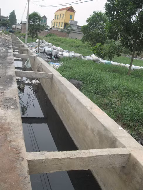 Lượng xỉ than, bột nhôm thải được người dân đổ ra ruộng, ao khiến diện tích nông nghiệp dần thu hẹp, dòng sông Ngũ Huyện Khê gần như “chết”, các loại cá tôm không thể sống trong môi trường nước ô nhiễm nặng nề… Lượng xỉ than, bột nhôm thải được người dân đổ ra ruộng, ao khiến diện tích nông nghiệp dần thu hẹp, dòng sông Ngũ Huyện Khê gần như “chết”, các loại cá tôm không thể sống trong môi trường nước ô nhiễm nặng nề…